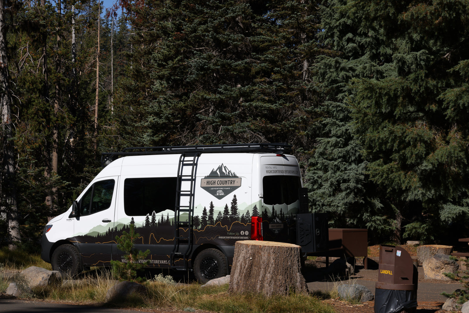 High Country RV rental camper van at a forest campsite. Ready for outdoor adventure and nature exploration.