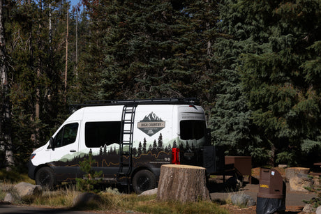 High Country RV rental camper van at a forest campsite. Ready for outdoor adventure and nature exploration.