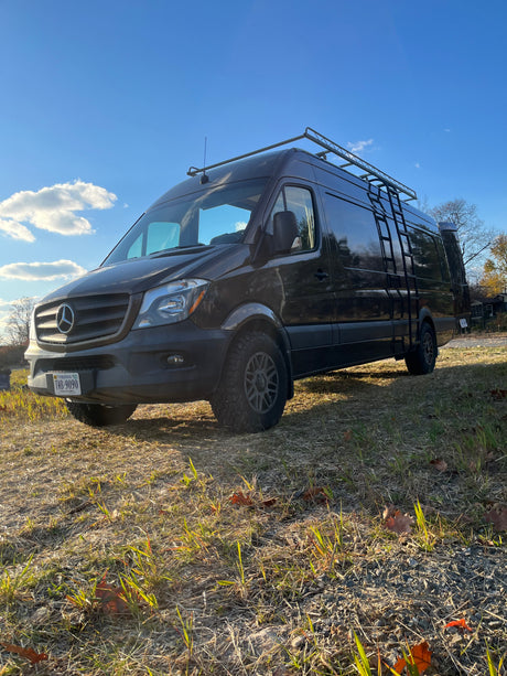 Explore with this Mercedes Sprinter camper van, equipped for adventure with a roof rack and ladder. Perfect for your next RV rental.