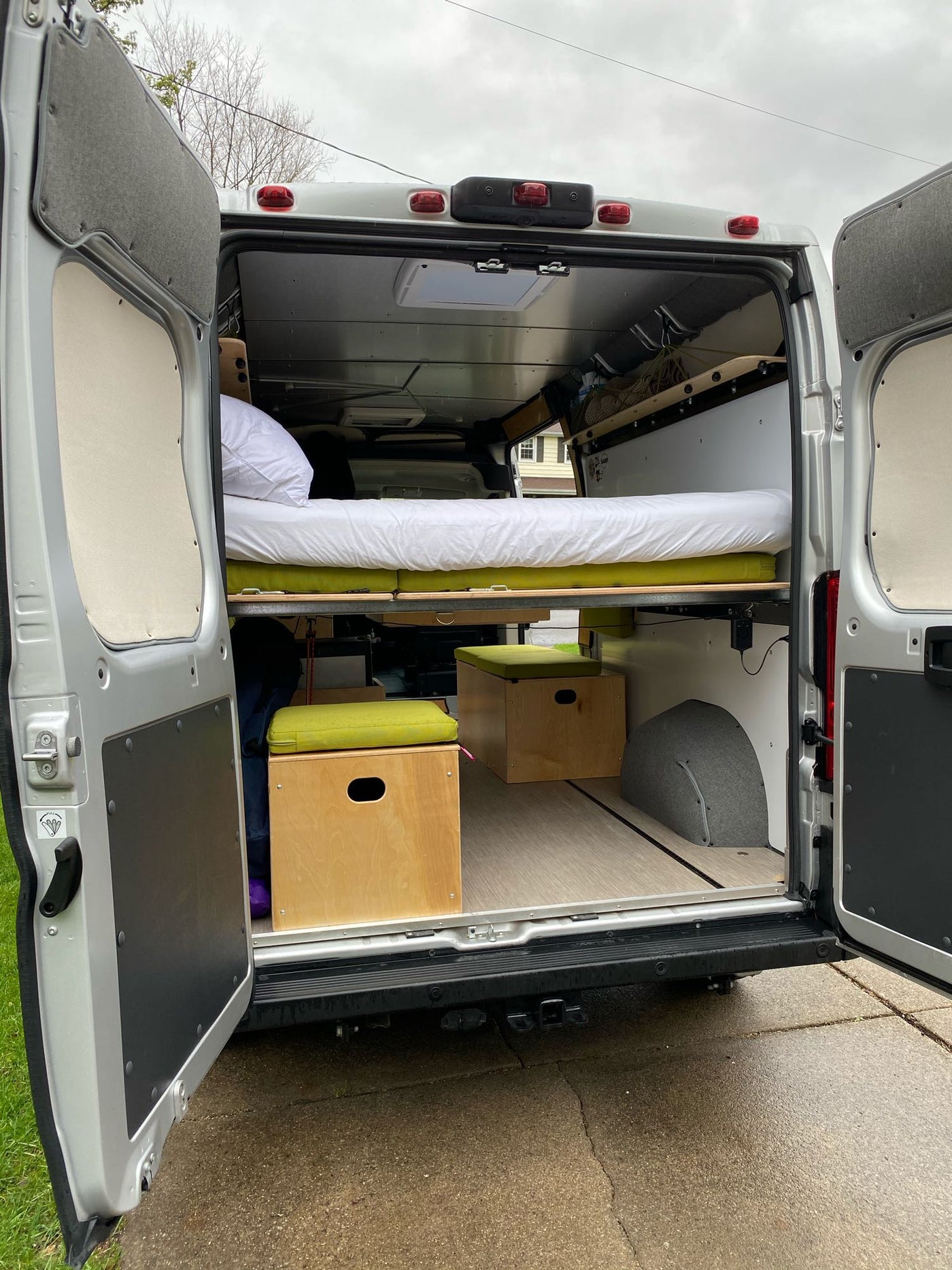  parked on a sunny residential street with houses.|Discover this custom Ram ProMaster RV rental's inviting interior: sink — photo 15