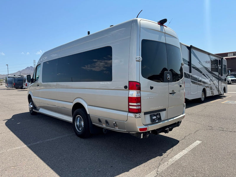 Light-colored Mercedes-Benz Sprinter luxury van by Ultimate Toys, great for an RV rental, parked in a lot with another RV. — photo 2