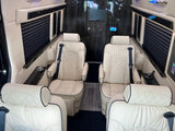 Luxurious RV rental interior: cream leather captain's chairs & dark wood accents. Ideal for comfortable travel.