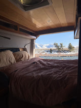  and blue cushioned seating.|Explore this cozy RV rental's clever camper van interior
