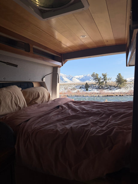  and blue cushioned seating.|Explore this cozy RV rental's clever camper van interior