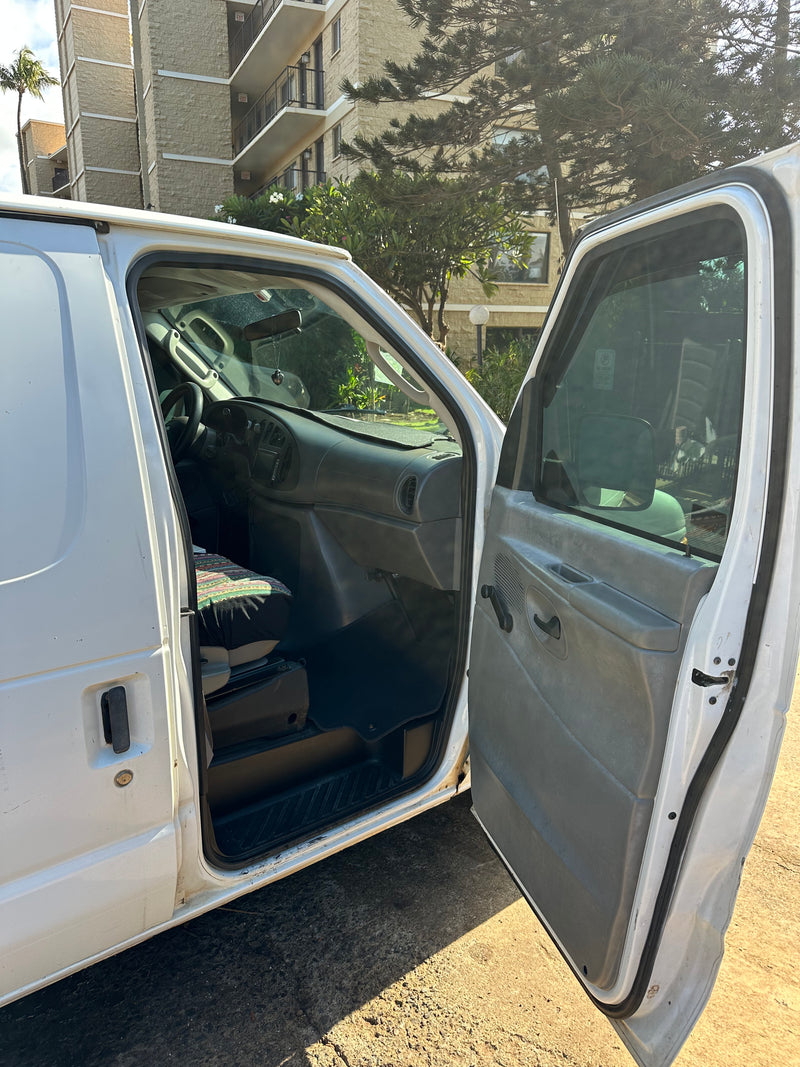 White van, open driver's door showing the cabin interior: dashboard, steering wheel, and a patterned seat, common for an rv rental. — photo 7