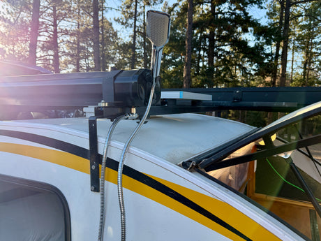 RV rental with an exterior chrome shower head and hose mounted on the roof rack, perfect for outdoor camping showers.