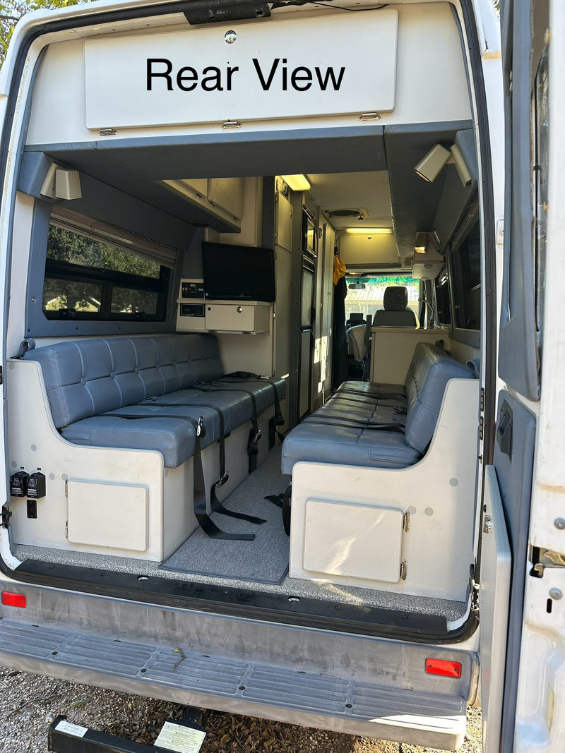  and front passenger & driver seats.|Spacious rv rental interior featuring comfortable gray tufted bench seats with seatbelts — photo 5