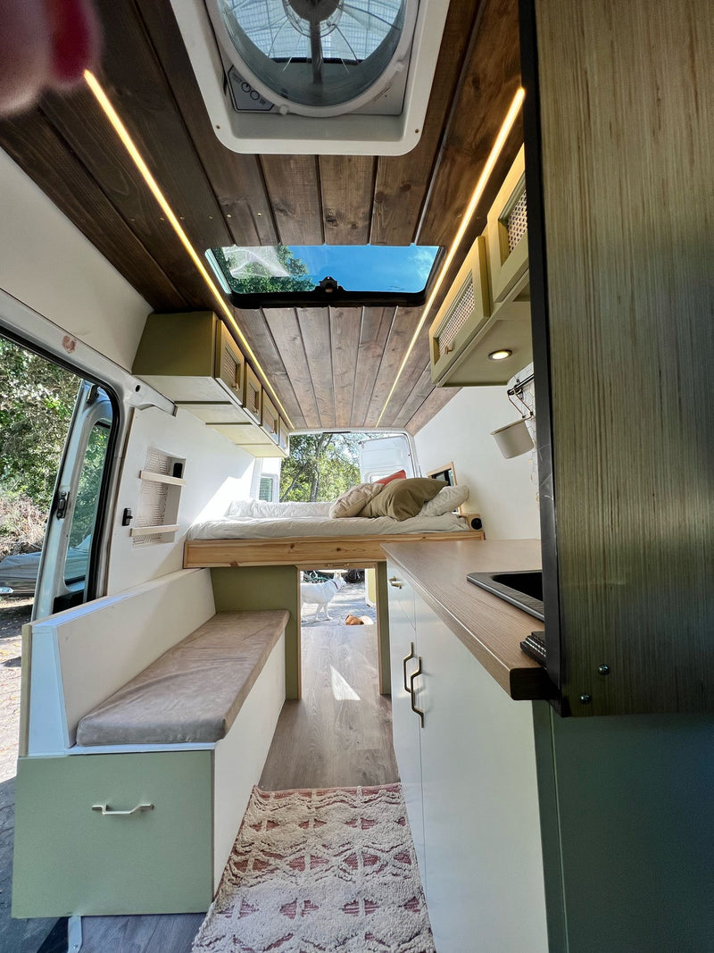 Step inside this RV rental! Enjoy a custom camper van interior with elevated bed — photo 1