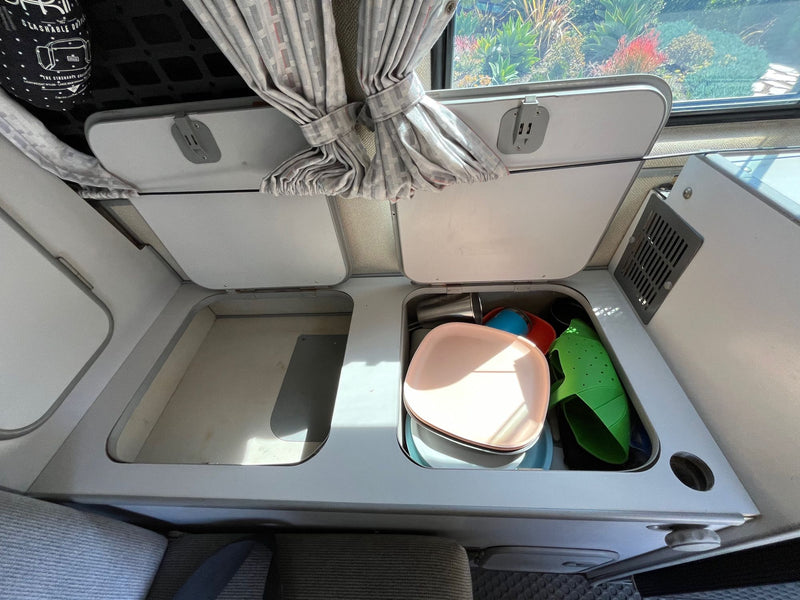  revealing four green Carlsberg beer bottles inside. Great camper amenity.|RV rental interior with open closet — photo 9