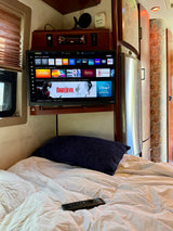 RV rental interior featuring a cozy bedroom, Vizio smart TV displaying streaming apps like Daredevil, and entertainment console.