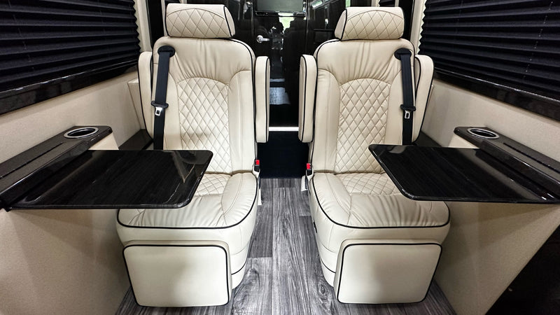 Two opulent cream leather captain's chairs with diamond quilting, tables, and cup holders inside a premium RV rental. — photo 13