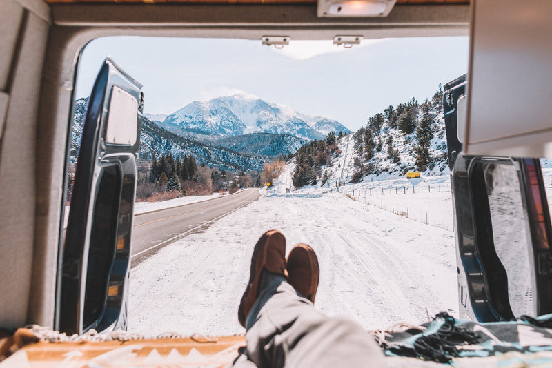 Feet up in an **rv rental**, enjoying snowy mountain vistas & a winter road. Perfect winter escape! — photo 9