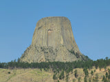 Devils Tower National Monument, a unique rock formation with vertical columns, under a clear sky.