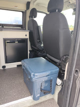 RV rental interior with black seats, Dometic fridge, and a blue Yeti Tundra 35 cooler. Ideal camper van setup.