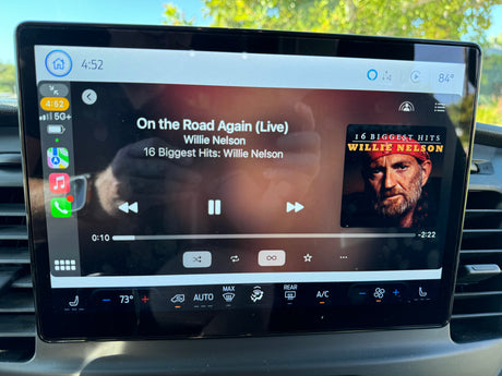 This RV rental's Apple CarPlay displays "On the Road Again" by Willie Nelson, with outside 84° and inside AC at 73°.