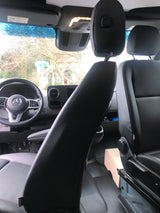 Interior of a Mercedes-Benz rv rental van, showcasing the dashboard, steering wheel, and passenger seats. Rain on windshield.
