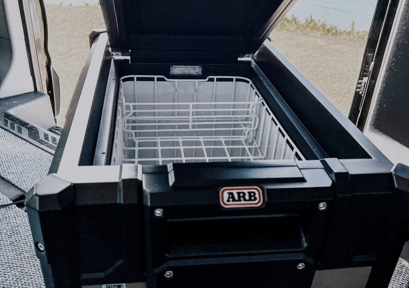 ARB portable fridge/freezer open in an RV rental, essential for fresh food on your road trip or camping adventures.