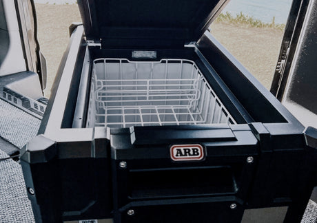 ARB portable fridge/freezer open in an RV rental, essential for fresh food on your road trip or camping adventures.