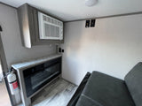 RV rental interior: Built-in AC, electric fireplace, and sofa ensure comfort for your travels.