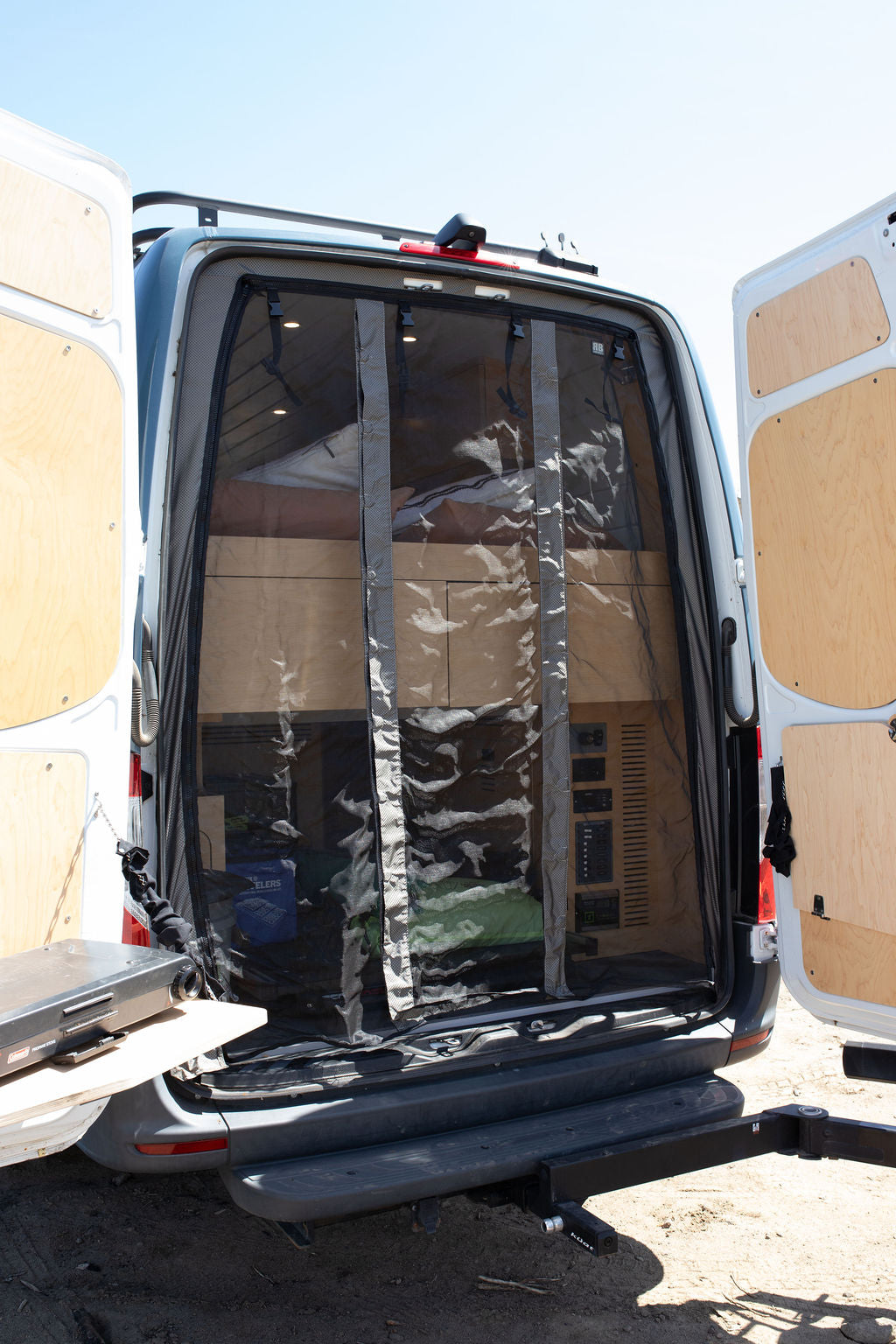  showing organized storage for camping gear like Lynx Levelers.|RV rental camper van's open rear — photo 4