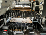 View inside an RV rental, featuring stacked bunk beds for sleeping, ample storage, and child car seats for family trips.