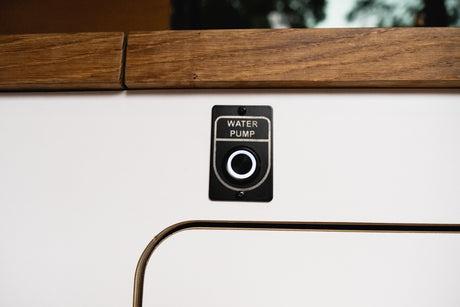 Illuminated 'WATER PUMP' button, a key control in an rv rental for fresh water access.
