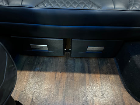 RV rental interior: Dometic under-seat drawer fridges, plush seating, and wood-look floor for comfortable campervan travel.