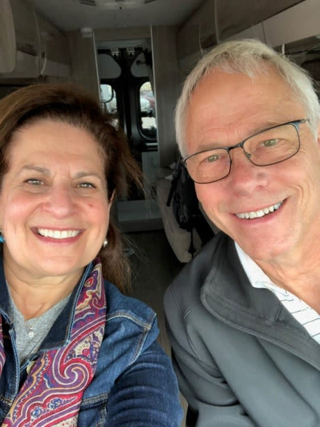 A happy couple smiles inside their RV rental, embarking on a road trip adventure.