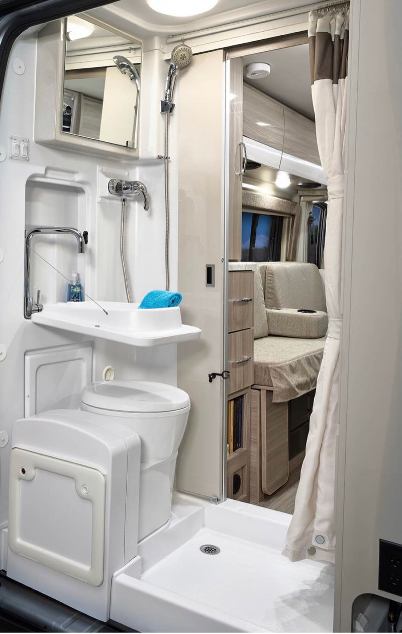  parked on a sunny street.|This RV rental interior features a comfortable grey bed — photo 6