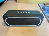 Portable 2Boom speaker on a light wood counter in an RV rental, next to a sink. Enjoy music and audio on your travels.