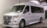 A silver Mercedes-Benz Sprinter van, converted for RV rental. High-roof, tinted windows, and custom wheels for travel.