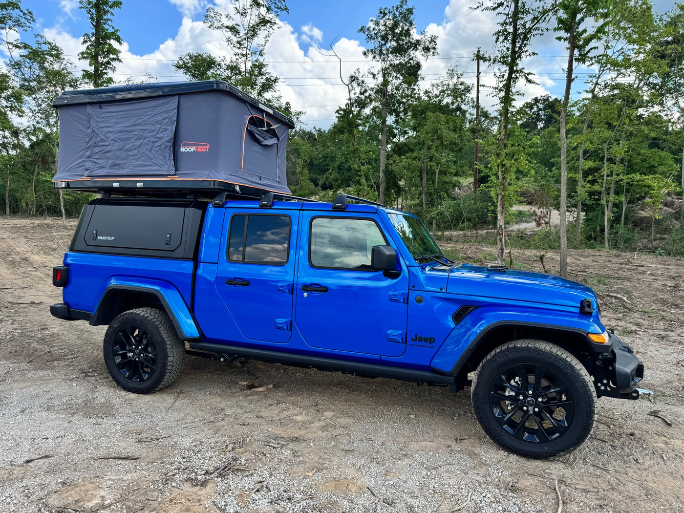  offers a unique RV rental experience for adventurers.|Blue Jeep Gladiator truck with Roofnest rooftop tent for an **RV rental** adventure. Perfect for outdoor camping!|Blue Jeep-style vehicle interior with open driver's door — photo 9