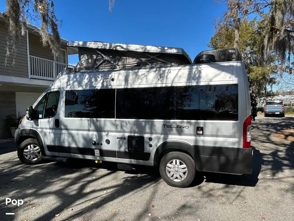 Silver Tellaro pop-top camper van for rv rental, featuring AC, parked outdoors under Spanish moss for your adventure.