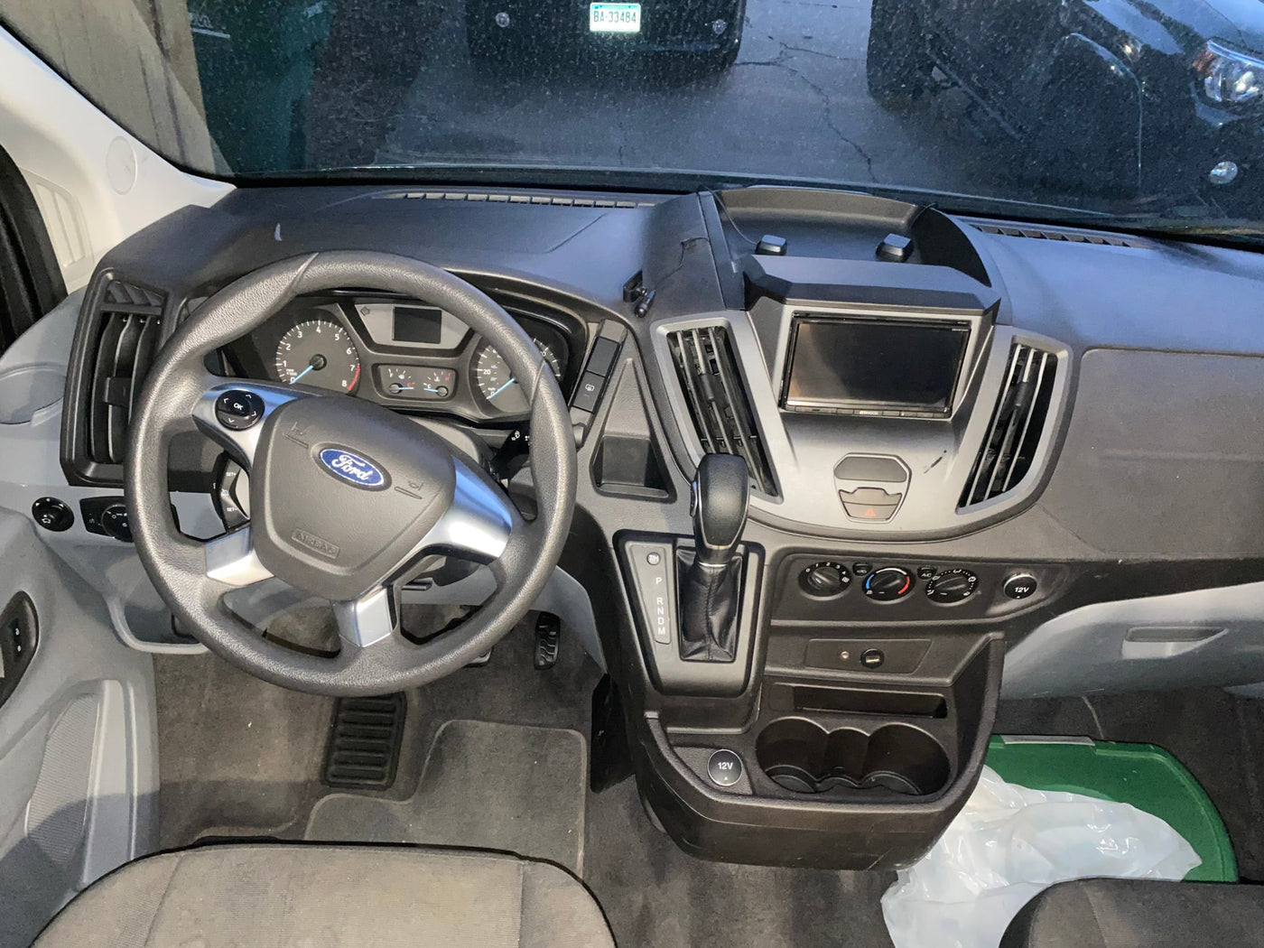 Driver's view of an RV rental van's interior, showing a Ford steering wheel, dashboard, automatic shifter, and climate controls. — photo 9