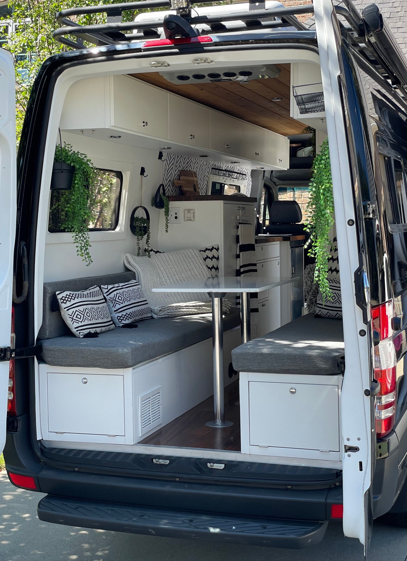 Inside a stylish RV rental, showcasing a compact dining area, kitchenette, and ample storage for comfortable travel.