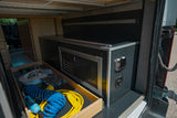 Inside an RV rental: rear storage with a pull-out drawer for gear and a custom power/utility module for convenience.