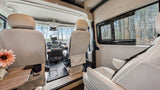 Step inside this luxurious rv rental: cream leather seats, driver's cockpit, and a tranquil forest view. Perfect for your road trip!
