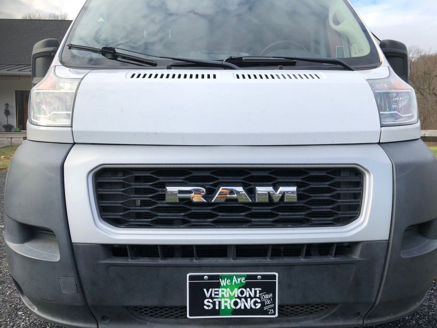 Front of a white Ram ProMaster van, a popular RV rental option, displaying a "Vermont Strong" plate.