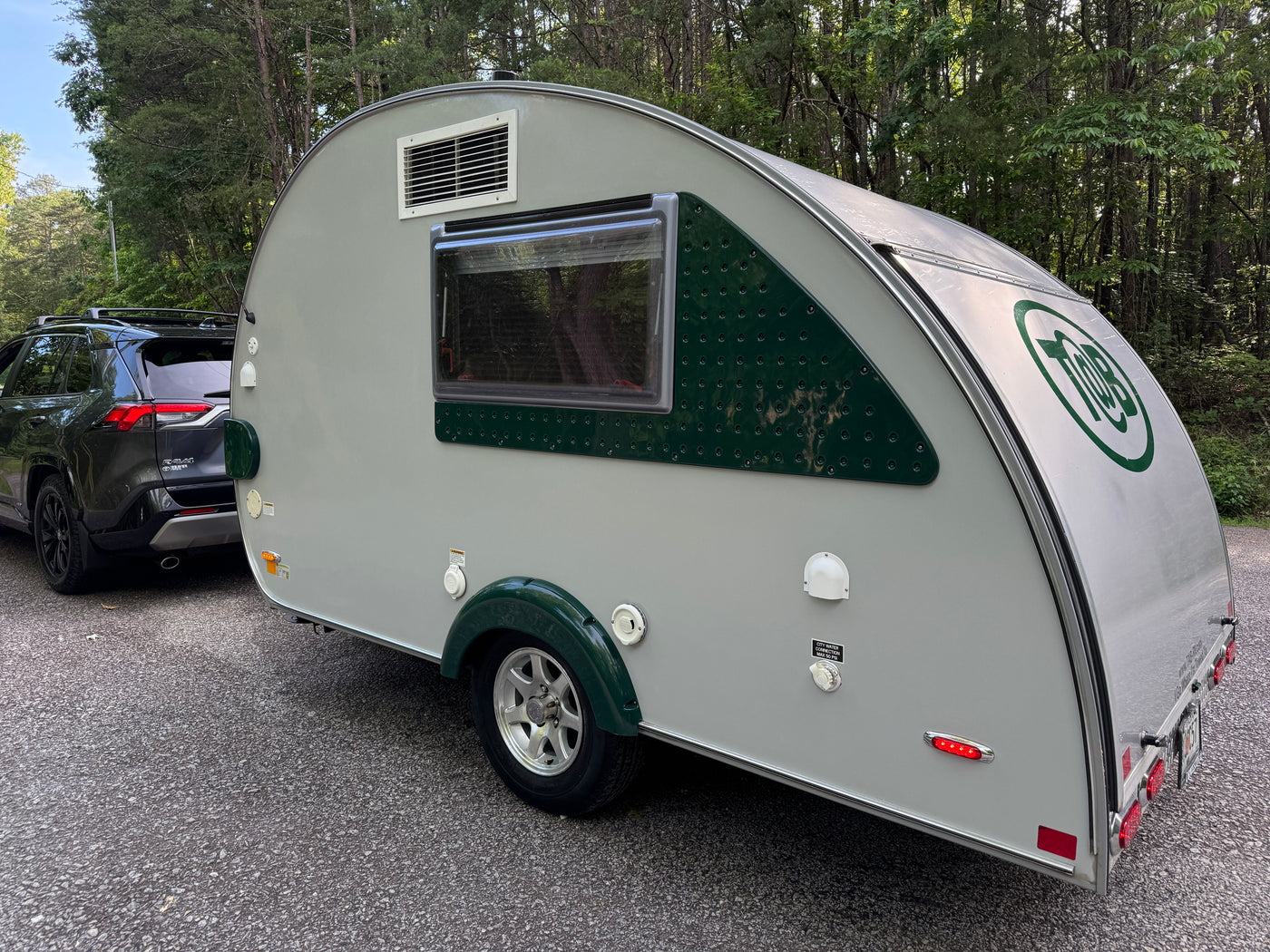 Grey and green T@B travel trailer hitched to a Toyota RAV4, an ideal RV rental for a camping trip in nature. — photo 4