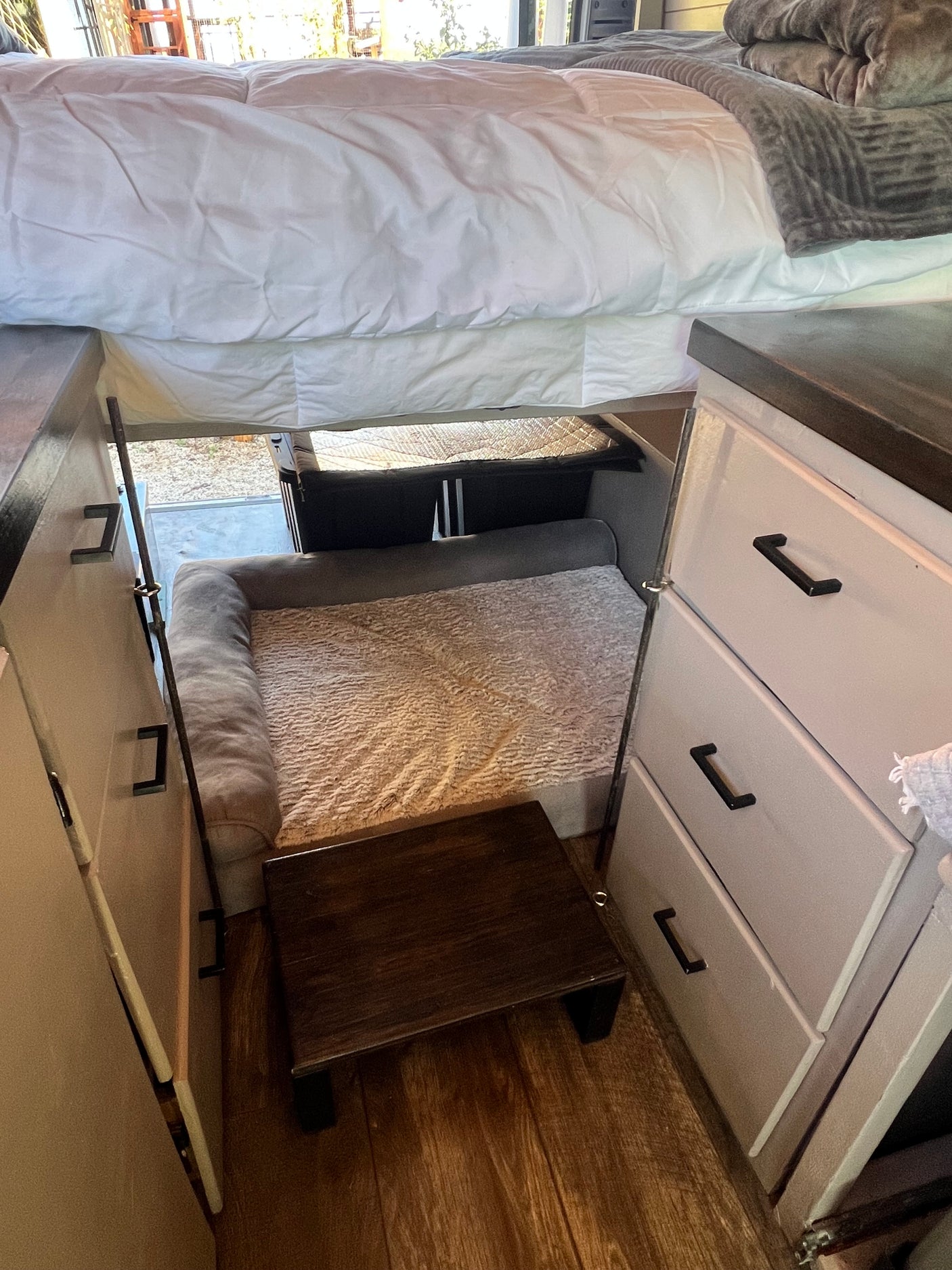 Cozy RV rental features an under-bed pet den with steps & clever storage. Perfect for tiny living adventurers.