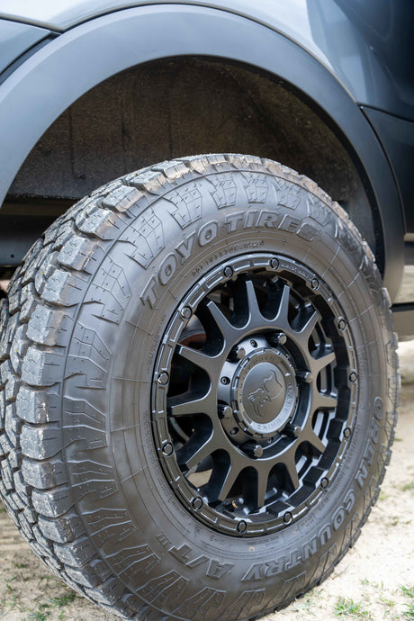 Rugged Toyo Open Country A/T tire and Black Rhino wheel on an RV rental, ready for off-road adventures.