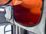 RV rental interior: An open gray fabric storage compartment with a bright orange lining, ready for your travel essentials.