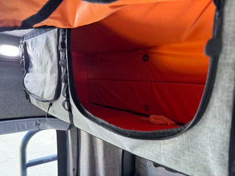 RV rental interior: An open gray fabric storage compartment with a bright orange lining, ready for your travel essentials.