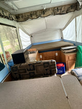 Experience a cozy RV rental pop-up camper interior with beds, kitchen, and dinette—perfect for your next camping trip.