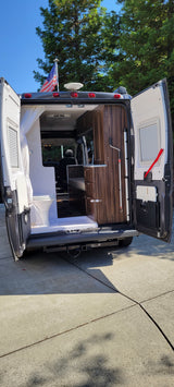 Explore this RV rental's interior: compact bathroom, kitchen, and an American flag proudly displayed on top. Perfect for travel.