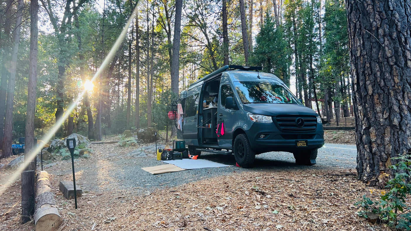  side door open to reveal a brightly lit interior and kitchen area.|A grey RV rental van — photo 10