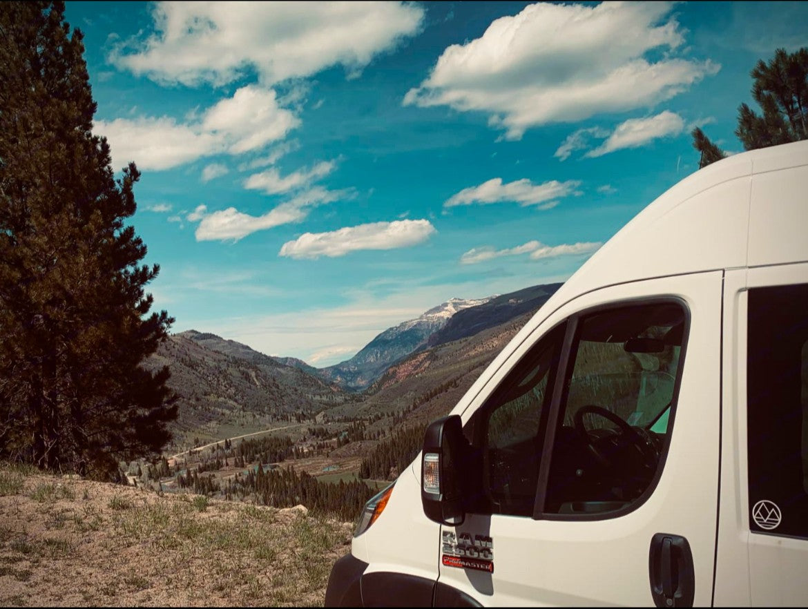 Scenic RV rental adventure! White van parked on a hillside overlooking a stunning mountain valley. #roadtrip #vanlife #travel