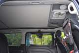 Comfortable RV rental interior: overhead fan, smoke detector, side window fan, and patterned curtains. Essential for camping.