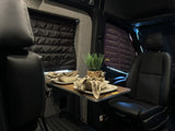 Cozy rv rental interior featuring a dining table set for two, plush seats, and insulated window coverings.