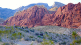 Scenic Red Rock Canyon: iconic red mountains, desert trails, and hikers on a path. Enjoy the views with an RV rental adventure.